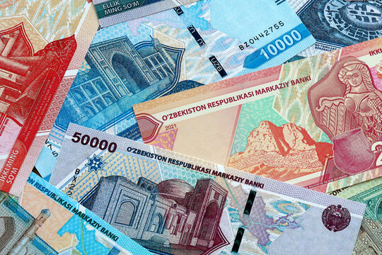 Uzbekistani som money banknotes pile on table. Uzbekistan bills of UZS currency close up