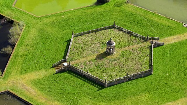 Top down aerial view of hexagonal water filter beds and central valve house, showcasing Victorian industrial symmetry in England.