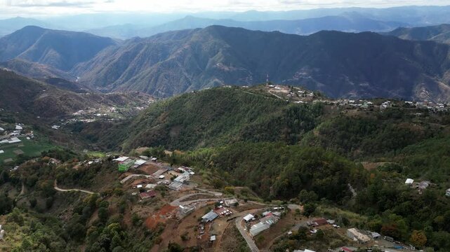 Drone aerial of Sacapulas, El Quiche, Guatemala, showing high-altitude pine forests, steep V-shaped valleys, Rio Negro basin, and 7W highway with village settlements.