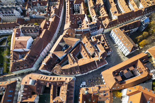 Aerial view of terracotta rooftops create a warm mosaic amidst the old town's narrow streets, a tapestry of history unfolding from above, Graz, Styria, Austria.