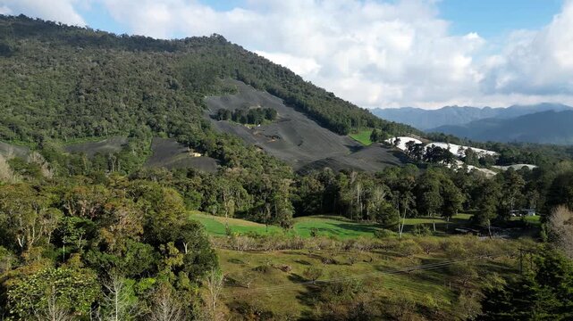 Drone shot moving forward over Guatemalan highlands near Coban, Alta Verapaz, showing contrast between lush rainforest and structured plantations.
