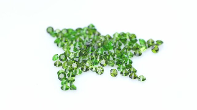 Loose Faceted Chrome Diopside Gemstones in Vibrant Green Color on White Background Macro Shot