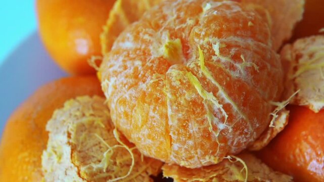 tangerines are shown on a table with one peeled