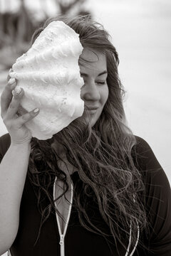 Giant Seashell by Woman&rsquo;s Face on Beach, Black and White Artistic Portrait

