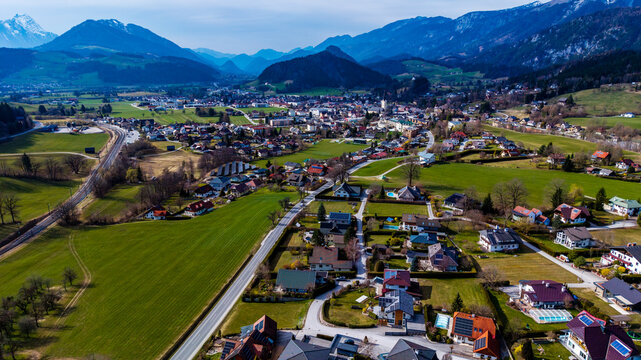 Aerial view of Windischgarsten valley nestled among verdant fields and framed by majestic mountains under a vast sky, Windischgarsten, Upper Austria, Austria.