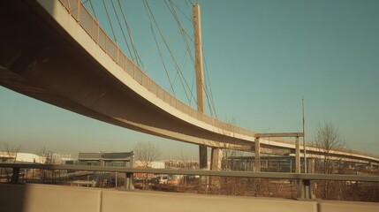 Naklejka premium Modern concrete cable stayed bridge and elevated highway structure spanning across an urban landscape, symbolizing connectivity, transportation, and engineering marvels under a clear sky
