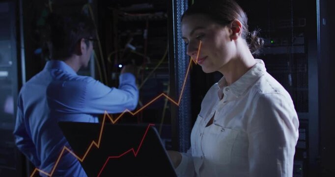 Woman reading data and flagging network alert, man tuning cables while graphs shifting over laptop