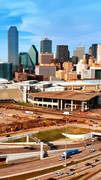 Going up above the busy roads in modern city. Drone flying over the construction site closer to downtown of Dallas, Texas, USA.