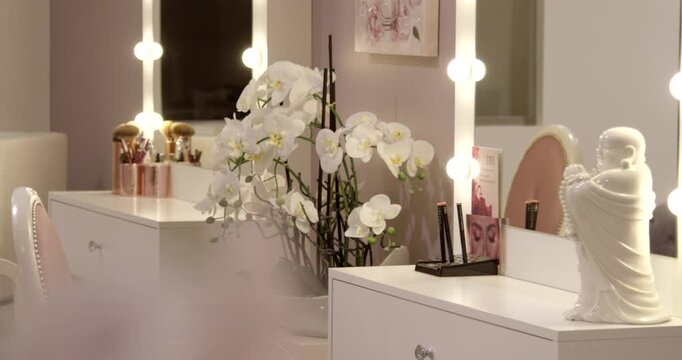 Modern vanity table with light-up mirror white orchid and elegant beauty salon decor