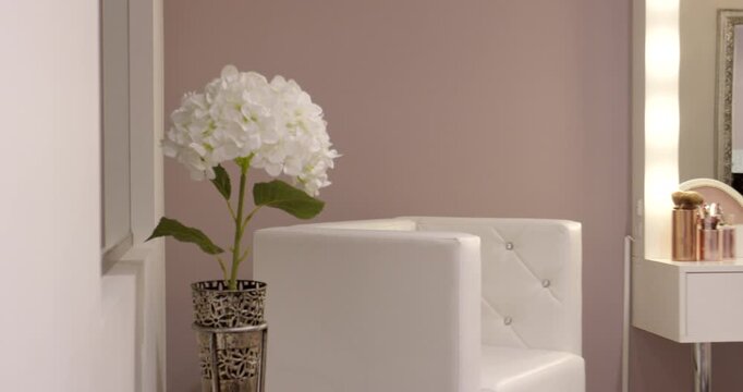 Elegant beauty salon interior with white vanity table light-up mirror and white floral decor
