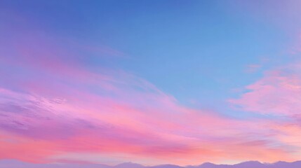 Obraz premium Tranquil Sunset Sky with Soft Pink and Blue Hues Over Mountain Landscape at Dusk with Calm Atmosphere