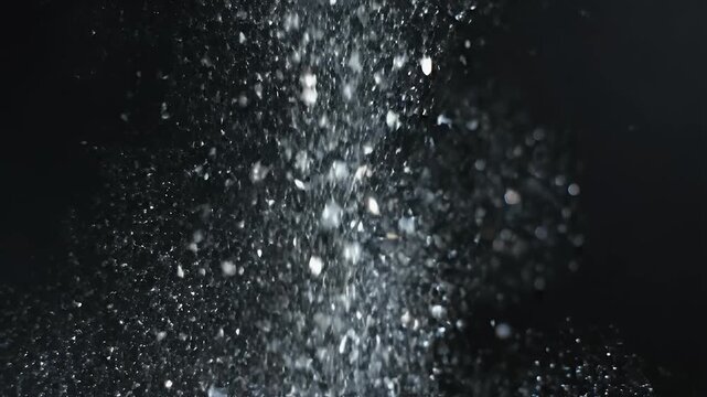A dramatic splash of white particles against a stark black background creates a dynamic and energetic visual.