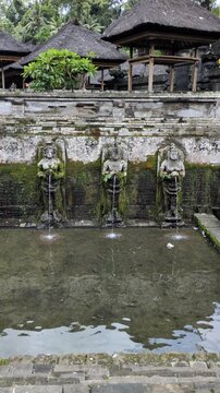 Ancient Balinese Water Fountain with Stone Goddess Statues at Tirta Empul Temple, Bali, Indonesia. Sacred Holy Springs for Spiritual Purification and Hindu Rituals.