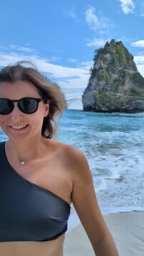 Blonde woman in bikini at Diamond Beach Bali Indonesia, tropical paradise with turquoise ocean and iconic cliffs, smiling female posing on sandy shore, travel wellness moment in exotic island seascape