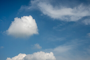 Obraz premium Fluffy white clouds and wispy cirrus formations in a blue sky