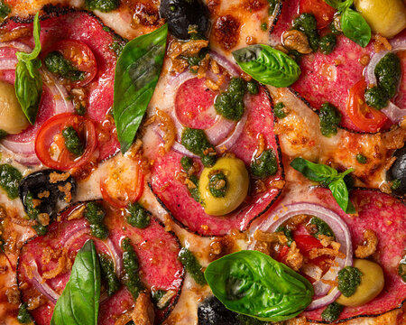 Gourmet pizza with salami, olives, cherry tomatoes