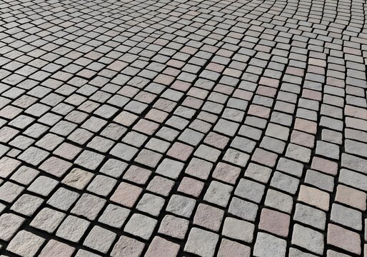 A textured visual showcases a repeating pattern of weathered stone pavers arranged intricately across an outdoor surface, offering a tactile sense of history and durable construction