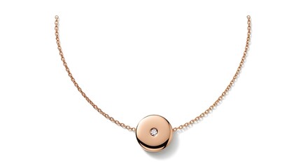 Fototapeta premium A beautiful rose gold necklace with a circular pendant featuring a small diamond is displayed on a white background.