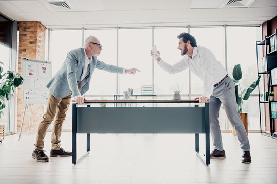 Business disagreement in a modern office two colleagues confront each other across the desk