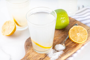 Fototapeta premium Healthy homemade Electrolyte Drink made with salt, sugar, citrus fruit (lemon and lime) juice. Sport isotonic beverage for good hydration