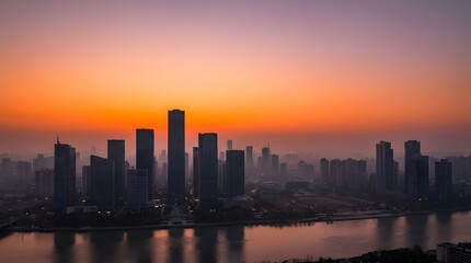 Fototapeta premium A modern city skyline illuminated by a vibrant sunset over a calm river