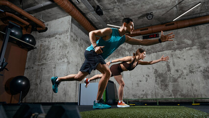Man and woman performing functional training movement with forward reach in gym. Concept of mobility training, balance development, fitness program and athletic performance © master1305