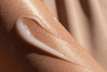 Fototapeta premium A close-up of a hand applying lip balm, highlighting the texture and shine on skin.