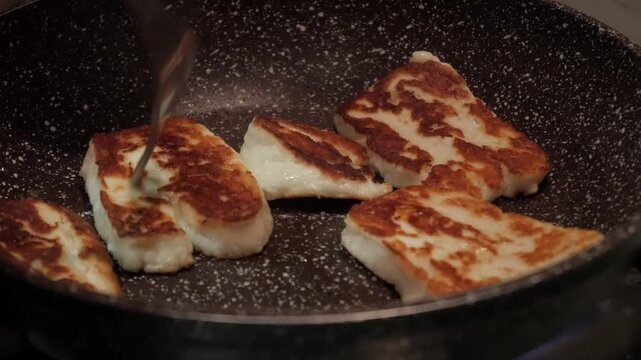 Grilling halloumi cheese in a hot pan, sizzling and golden brown