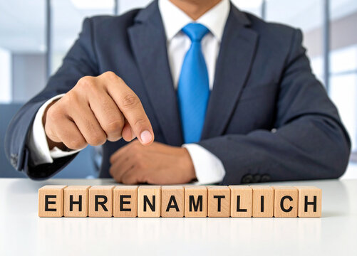 Ehrenamtlich - Geschäftsmann zeigt auf das Wort "Ehrenamtlich"