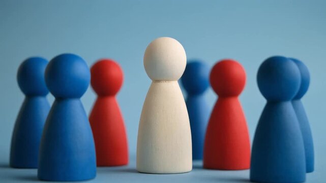 A white pawn stands among red and blue pieces on a blue surface, symbolizing individuality, leadership, and standing out from the group.