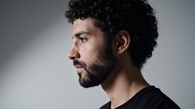 Close-up profile shots of a man with curly hair and beard looking to the side in different angles with soft lighting and neutral background for portrait