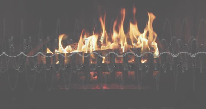 Embers smoldering on grate flickering flames growing logs, collapsing then reigniting fire dance