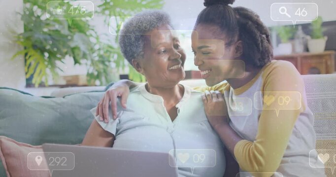 Vertical video: Mother and daughter leaning, daughter tapping laptop teaching social media overlays