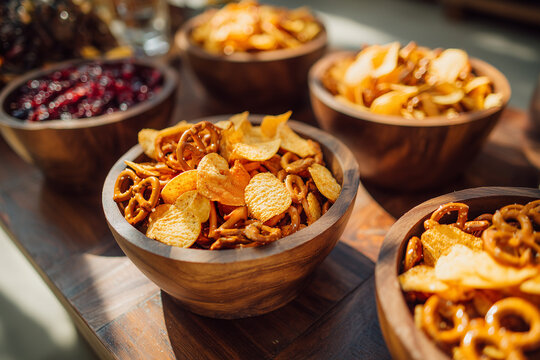 Buffet snack table with chips pretzels and appetizers in warm restaurant lighting