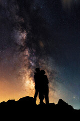 Fototapeta premium Silhouettes of lovers against the backdrop of the colorful Milky Way galaxy.
