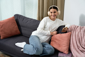 Obraz premium Teenage girl enjoying a cozy moment at home in her modern apartment with music