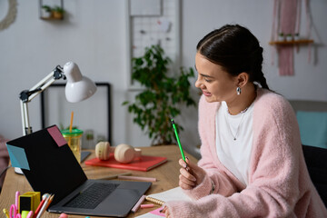 Creative teenage girl enjoying her time in a cozy modern apartment workspace