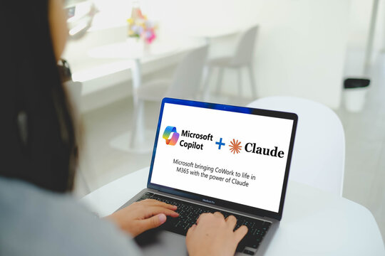 Bangkok, Thailand. April 10, 2026; A person is typing on a laptop that displays a presentation about the integration of Microsoft Copilot and Claude AI services.