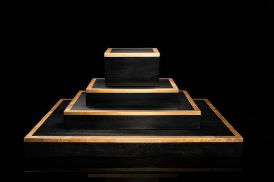 Empty black marble podium with gold line accent in spotlight. Square display stand for product presentation 