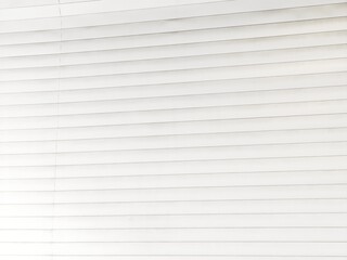 Obraz premium Closeup of clean white horizontal window blind slats arranged in evenly spaced parallel rows, creating a simple bright minimalist striped pattern with subtle shadows.