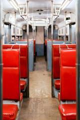 Fototapeta premium Empty vintage tram interior with red seats and symmetrical perspective in Alexandria Egypt