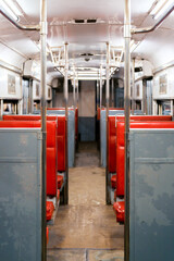 Fototapeta premium Retro tram interior with red seating and metal handrails