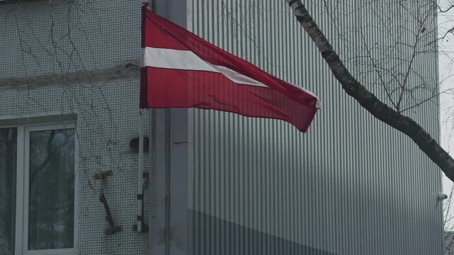 Latvian flag: Cinematic footage showcasing gentle breeze and muted overcast sky