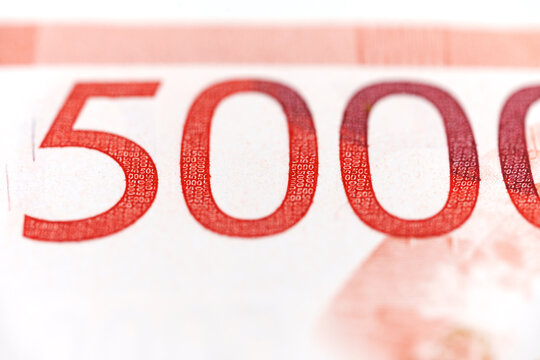 Details of a 5000 currency note captured close up in a bright setting