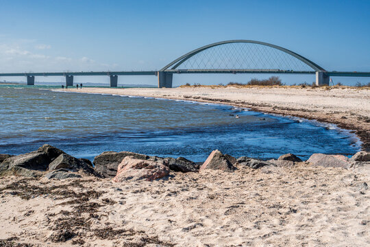 Der Strandabschnitt bei Fehmarnsund mit Fehmarnsundbr&uuml;cke auf der Ostseeinsel Fehmarn