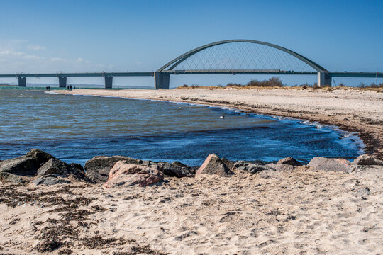 Der Strandabschnitt bei Fehmarnsund mit Fehmarnsundbr&uuml;cke auf der Ostseeinsel Fehmarn