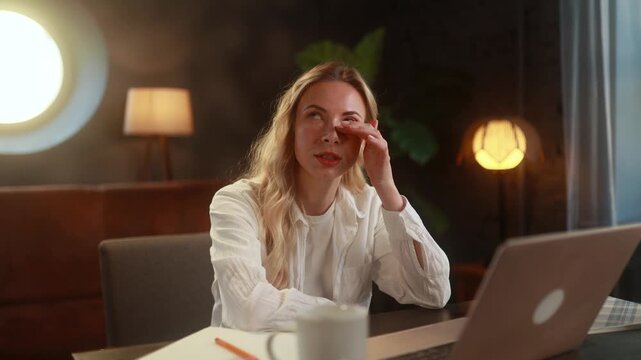 Young woman having an online therapy session on her laptop, speaking openly about her emotions and receiving support in a calm home environment