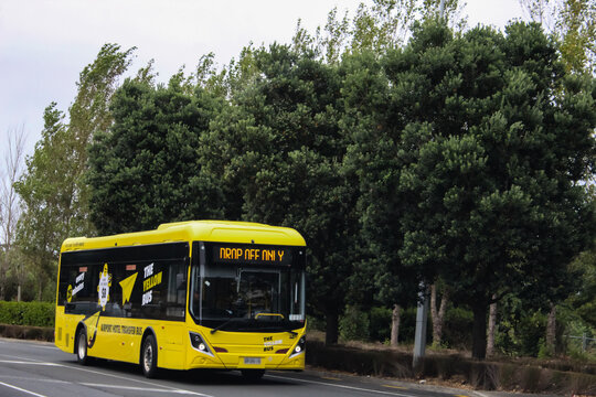 Auckland, New Zealand - Mar 12, 2026:  A yellow electric bus, utilized as an airport transfer shuttle in New Zealand. Editorial Use Only.