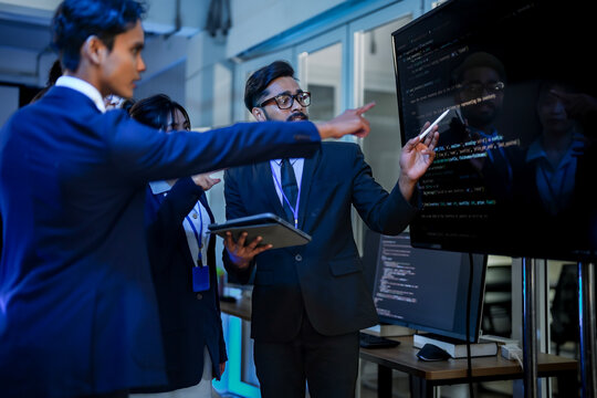 Senior software architect conducting rigorous backend code review with development team. Technical lead analyzing syntax optimization strategies on digital interface.