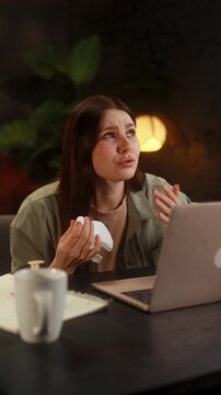 Vertical video of woman having an online therapy session with a psychotherapist via laptop at home speaking openly and emotionally discussing personal feelings in safe and supportive distance place 